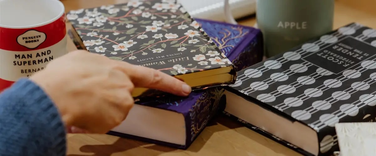 A small pile of hardback books with artful covers.