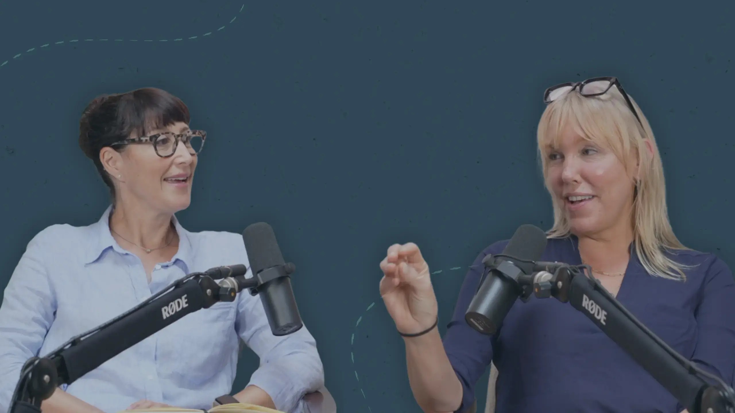 Authors and writing coaches Gina Sorell and Tara Conklin, shown sitting beside recording microphones, discuss the art of naming your novel.