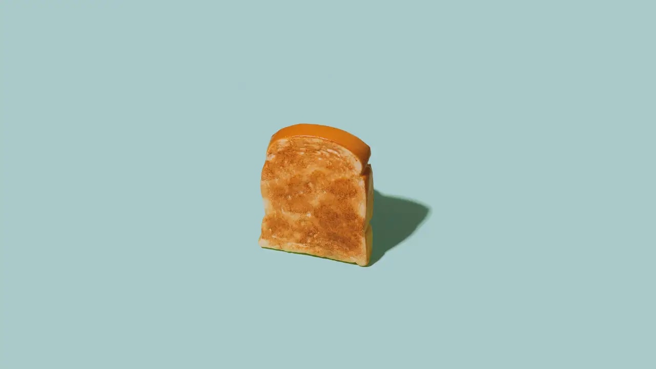 A piece of toast stands upright, casting a shadow on the ground, ready to fall either backward or forward.
