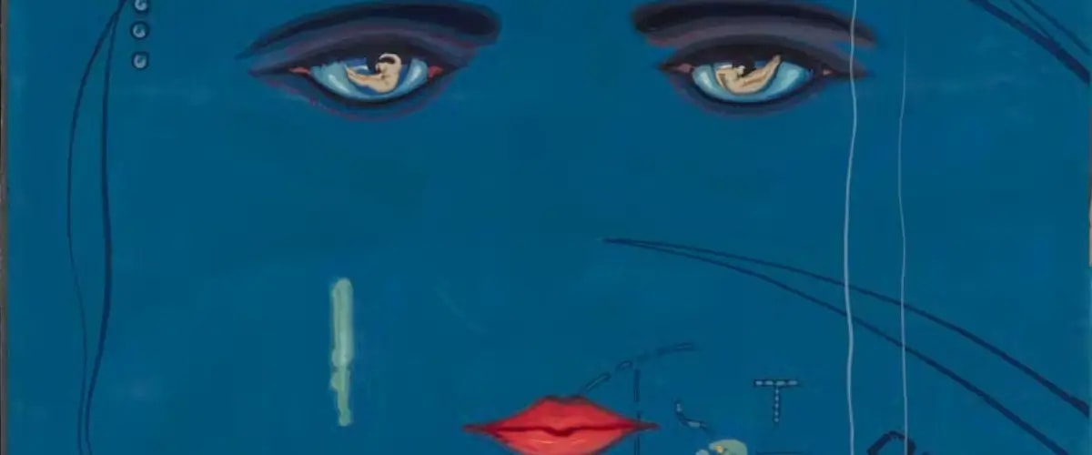 The artistic eyes and lips on a blue face of The Great Gatsby's cover art.