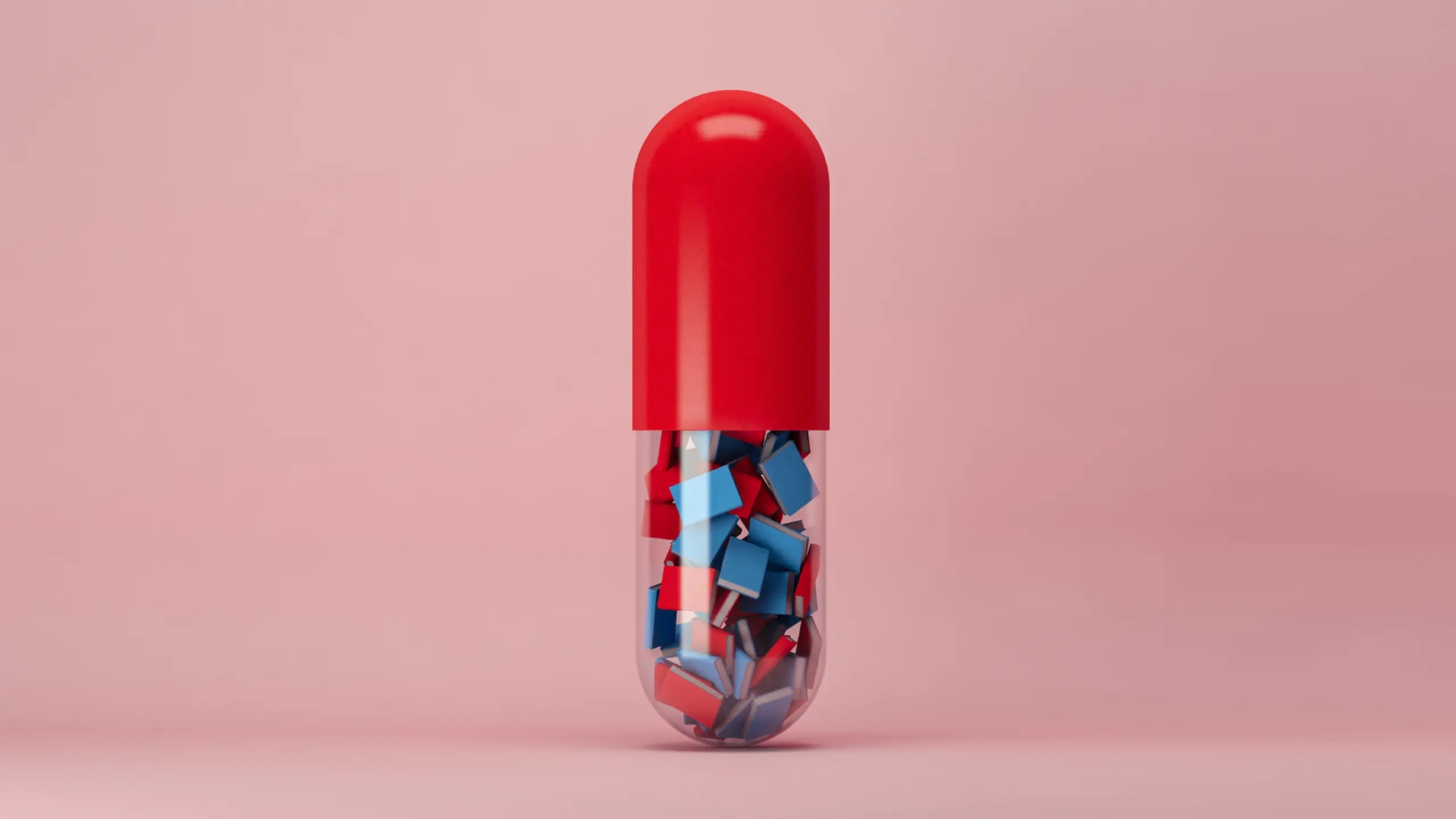 A red and transparent pill capsule containing lots of tiny red and blue books.